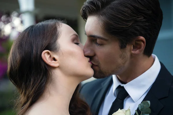 Romántica pareja recién casada besándose en el parque — Foto de Stock