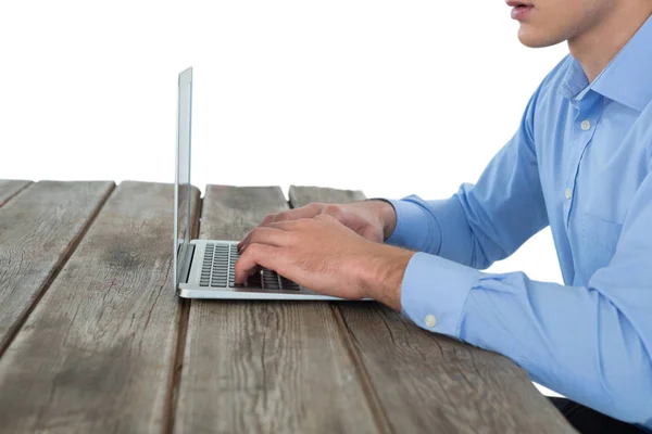 Бизнесмен, работающий над ноутбуком за столом — стоковое фото