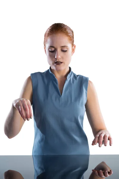 Businesswoman using imaginary interface at table — Stock Photo, Image