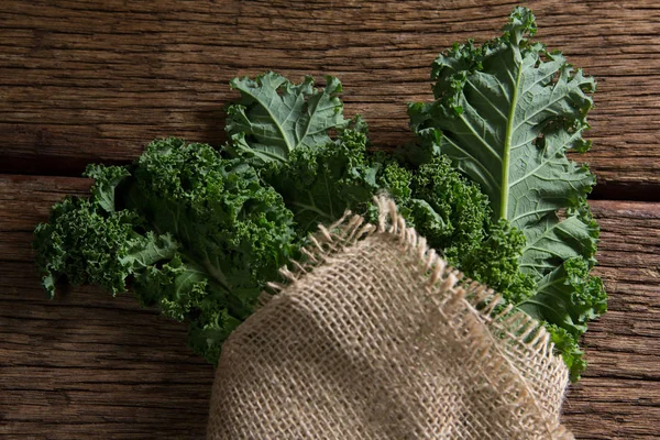 Verduras de mostarda embrulhadas na mesa de madeira — Fotografia de Stock