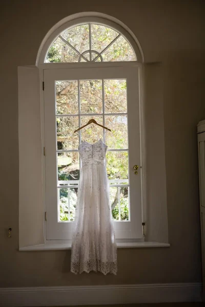 Brudklänning hänger på fönster i rummet — Stockfoto