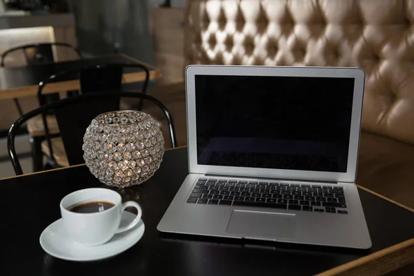 Coffee, laptop and lit candle on table — Stock Photo, Image