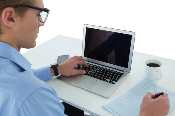 Geschäftsmann benutzt Laptop beim Schreiben von Dokumenten — Stockfoto