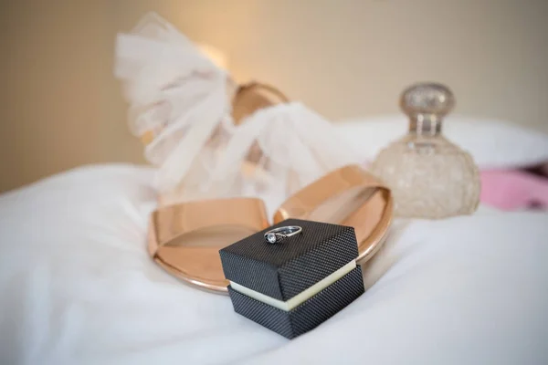 Сандалии с парфюмерным опрыскивателем и обручальное кольцо — стоковое фото