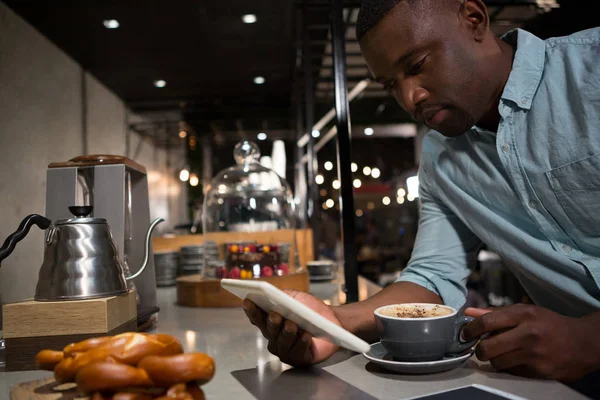 Человек с помощью планшета во время кофе — стоковое фото