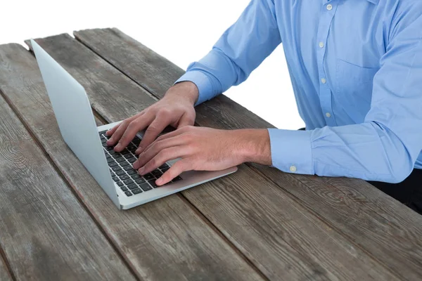 Бизнесмен с помощью ноутбука за деревянным столом — стоковое фото
