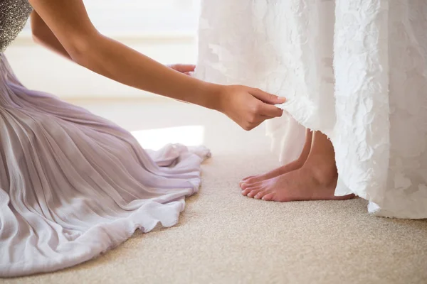 Bruidsmeisje bruid helpen klaar — Stockfoto