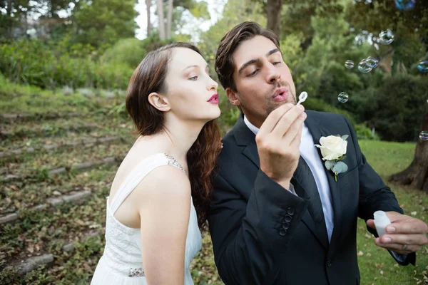 Yeni evli çift üfleme kabarcıklar — Stok fotoğraf