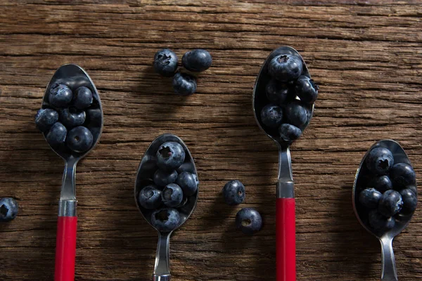 蓝莓中排列在桌上的勺子 — 图库照片