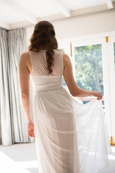 Νύφη στο γάμο φόρεμα στέκεται στο σπίτι — Φωτογραφία Αρχείου