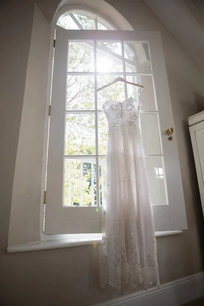 Gaun pengantin tergantung di jendela — Stok Foto