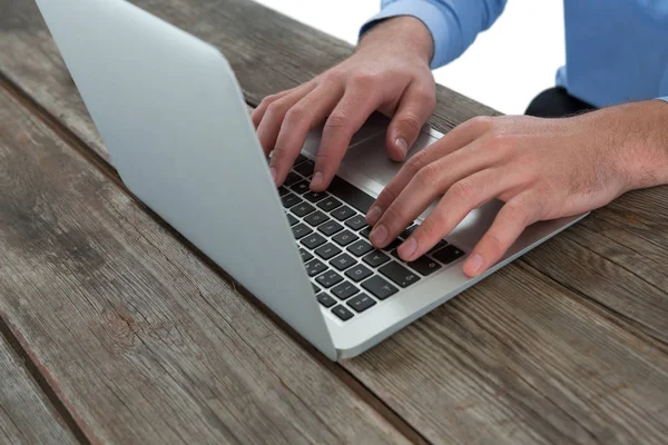 Zakenman met behulp van laptop aan houten tafel — Stockfoto