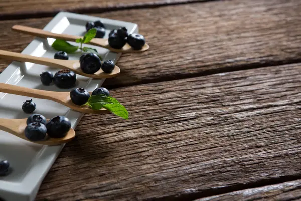 Arándanos con menta en cuchara de madera —  Fotos de Stock