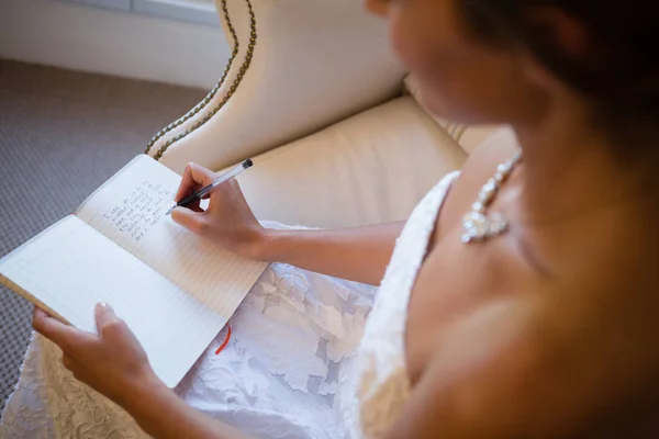 Bride writing in diary — Stock Photo, Image