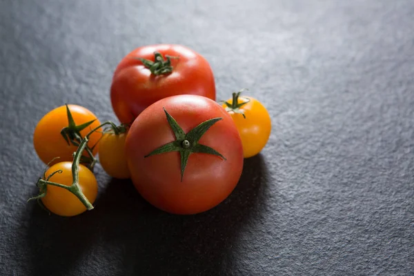 Tomatoes on black background — Stock Photo, Image