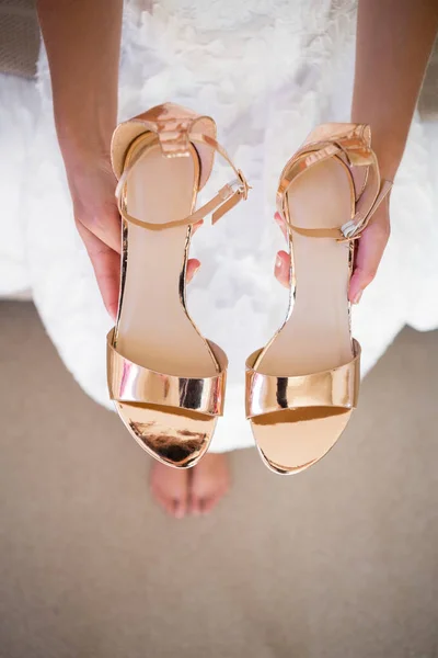 Noiva segurando sandálias — Fotografia de Stock