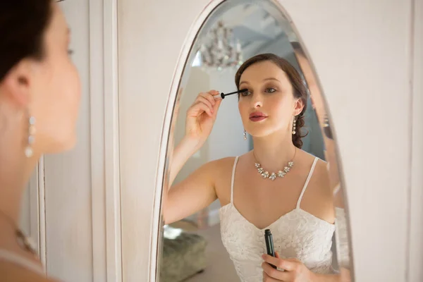Braut trägt Wimperntusche auf Spiegel auf — Stockfoto