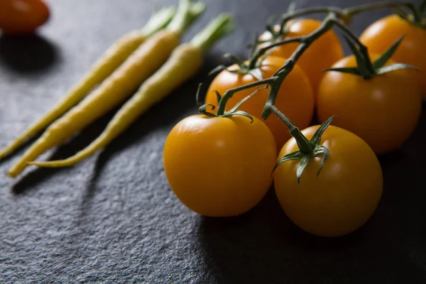 Havuç ve domates siyah arka plan üzerine — Stok fotoğraf