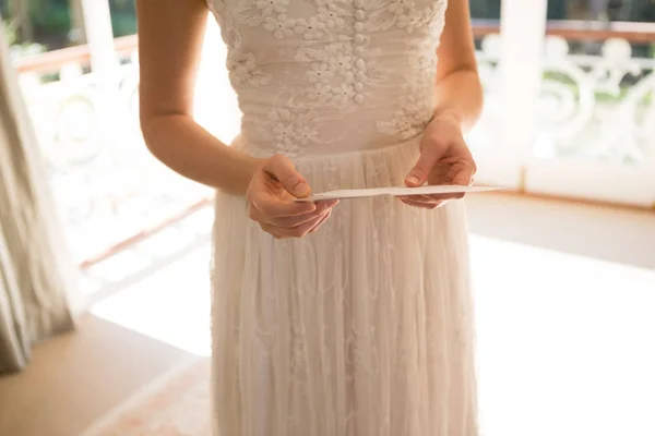 Braut hält Hochzeitskarte zu Hause — Stockfoto