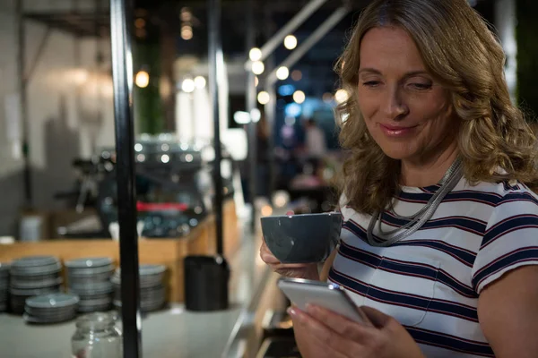 Mujer usando el teléfono mientras toma café — Foto de Stock