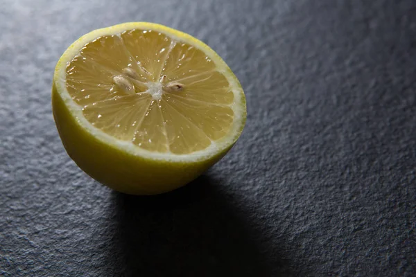 黒い背景に半分レモン — ストック写真