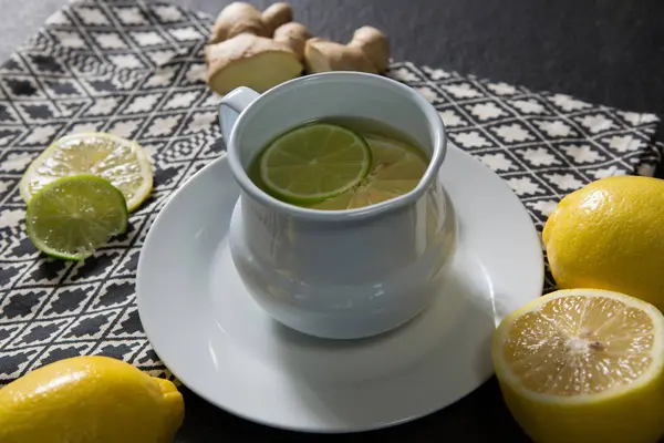 Teetasse mit Zitrone auf schwarzem Hintergrund — Stockfoto