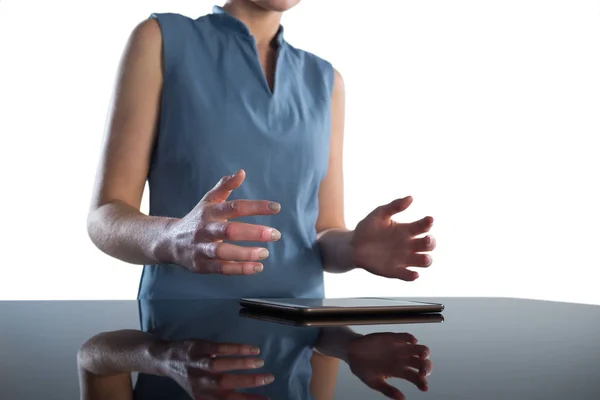Zakenvrouw gebaren over digitale tablet aan tafel — Stockfoto