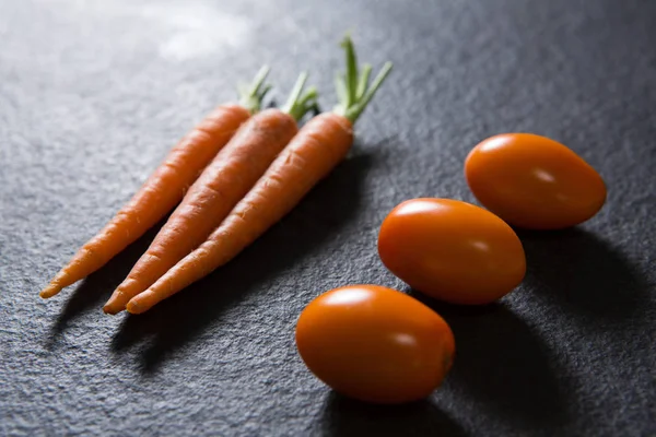 Морква і помідори на чорному тлі — стокове фото