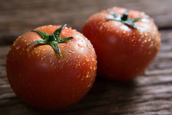 Tomates frescos molhados na mesa de madeira — Fotografia de Stock