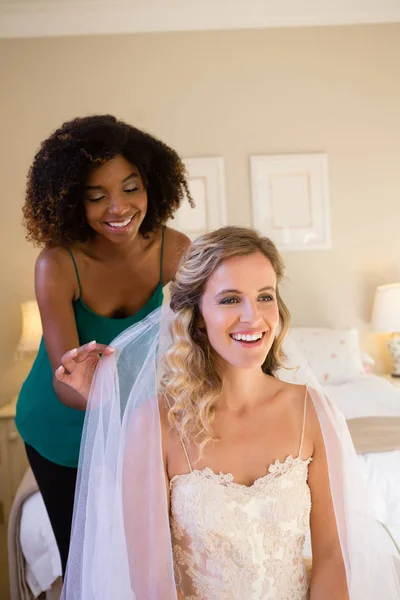 Beautician adjusting veil of bride hair — Stock Photo, Image