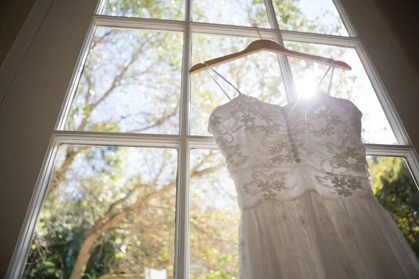 Hochzeitskleid hängt am Fenster im Zimmer — Stockfoto
