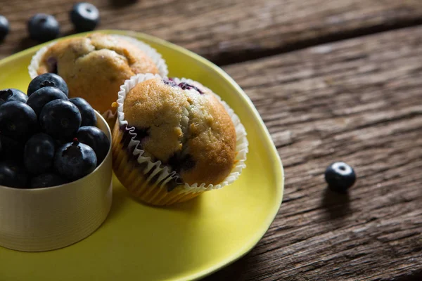 Blaubeeren und Muffins auf Teller — Stockfoto