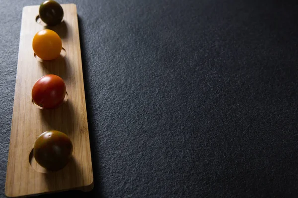 Vários tomates organizam na bandeja de madeira — Fotografia de Stock