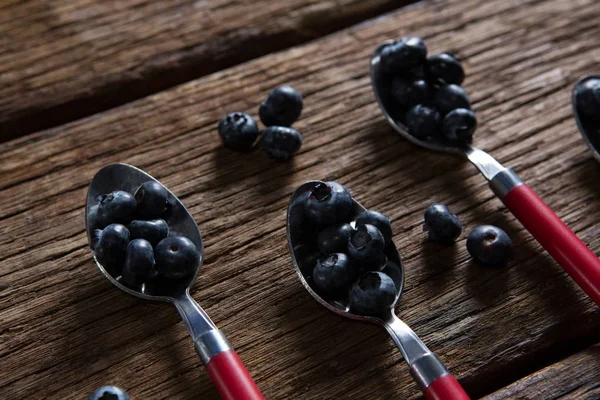 Blaubeeren in Löffel auf Tisch arrangiert — Stockfoto