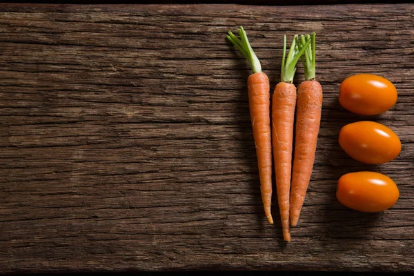 Морква і помідори на дерев'яному столі — стокове фото