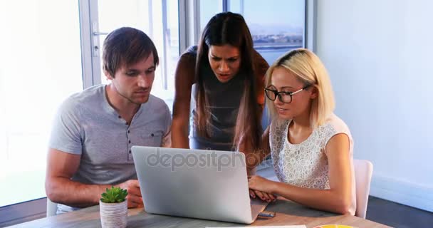 Ejecutivos discutiendo sobre portátil durante una reunión — Vídeos de Stock