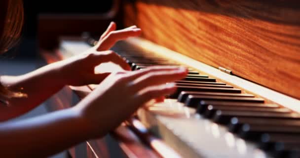 Schoolgirl learning piano in music class — Stock Video