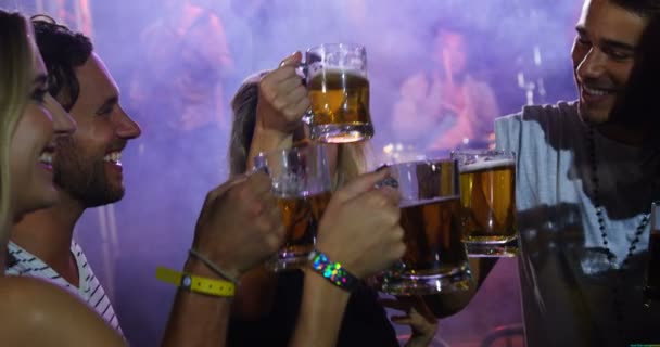 Группа друзей тост кружки пива на концерте — стоковое видео