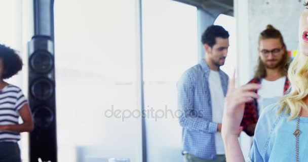 Woman talking on mobile phone with her colleagues — Stock Video