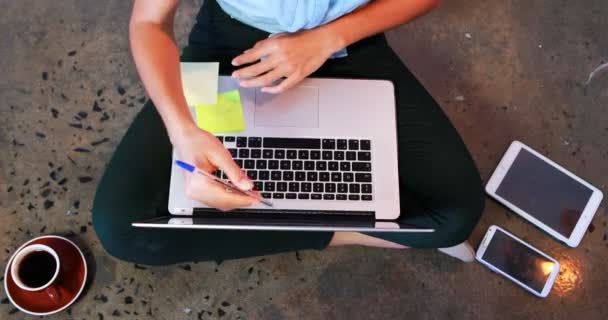 Escrita executiva em nota pegajosa enquanto trabalhava no laptop — Vídeo de Stock