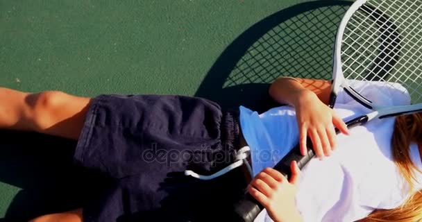 Schülerin entspannt auf Tennisplatz — Stockvideo