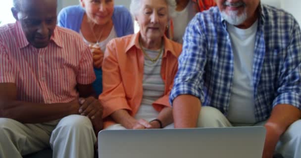 Щасливі старші друзі розважаються під час використання ноутбука — стокове відео