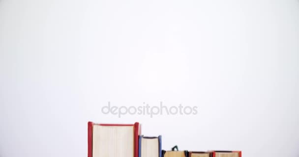 Яблоко и книги на деревянном столе — стоковое видео