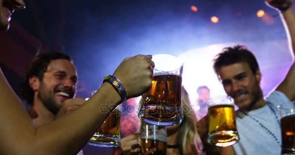Друзья пьют кружки с пивом на концерте — стоковое видео