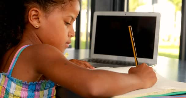 Schoolgirl doing homework in library — Stock Video