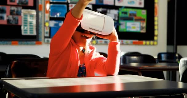 Schoolgirl using virtual reality headset in classroom — Stock Video