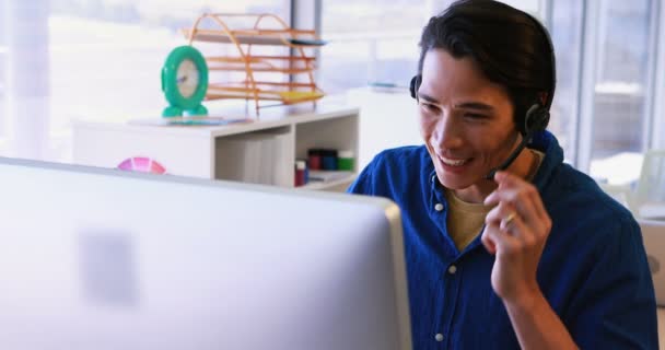 Ejecutivo en auriculares trabajando sobre la computadora — Vídeos de Stock