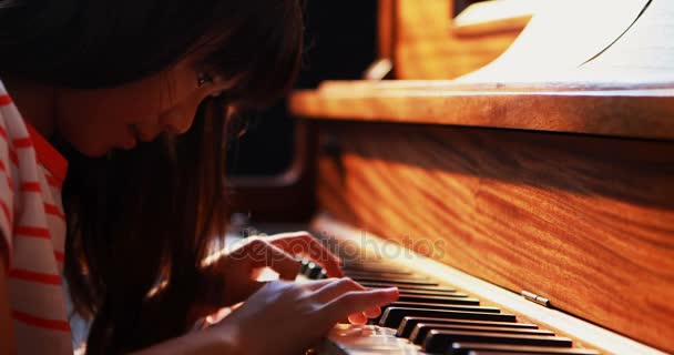 Школьница учит фортепиано в музыкальном классе — стоковое видео