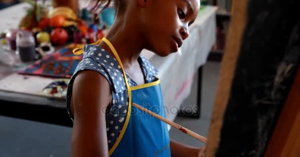 Cute schoolgirl painting on canvas — Stock Video