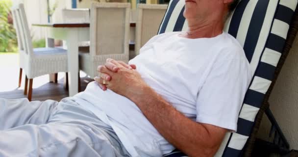 Senior homme relaxant dans le porche — Video